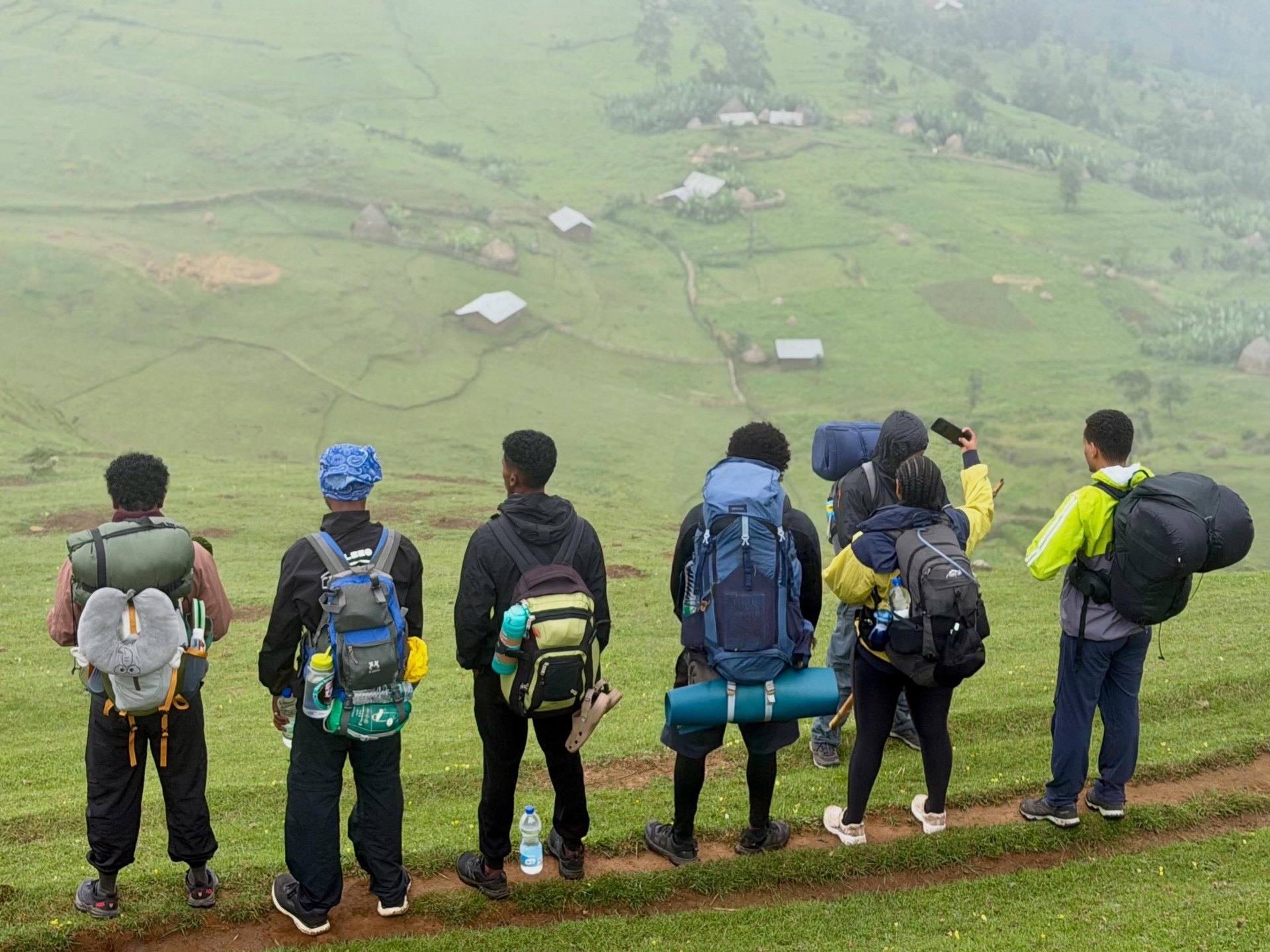 Trekking group overlooking a misty highland village